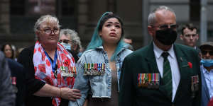 Megan Rull,second from left,whose partner took his own life last year,is comforted at the Remembrance Day service in Martin Place on Thursday.