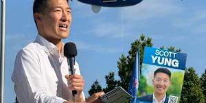 Scott Yung speaking during the federal election campaign,with an advertising blimp hovering overhead.