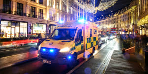 An ambulance queues in traffic beneath the Christmas decorations on Regent Street in London.