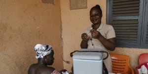 Deborah Sebi (R),prepares a vaccination for Rebecca Bamembaye’s 3-month-old,Doris,at the Teshie mobile clinic. 
