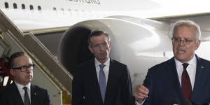 Qantas CEO Alan Joyce,left,NSW Premier Dominic Perrottet and Prime Minister Scott Morrison speaking to the media regarding international travel.