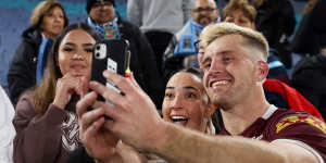 Cameron Munster takes a selfie with a fan after the Maroons won game one.
