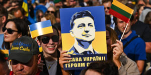 A woman holds a banner with the President of Ukraine,Volodymyr Zelensky portrait during the Raising the Flag for Ukraine NATO event in Vilnius,Lithuania.