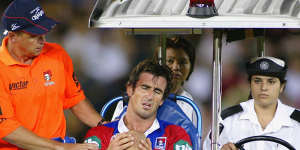 Andrew Johns is taken off the field after injuring his knee during a league match in 2004 in Sydney.