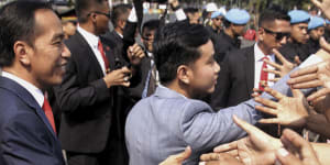 Indonesia’s President Joko Widodo and his son Gibran Rakabuming Raka greet supporters in 2019.