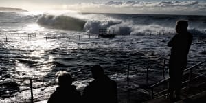 Spectators watch the monster waves roll in at Dee Why early on Monday.