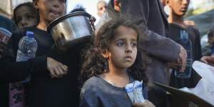 A Palestinian girl queues for food in Deir al-Balah,Gaza Strip,on Monday.