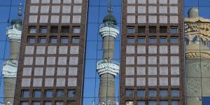 The minarets of the Urumqi International Grand Bazaar Mosque are reflected on nearby building. Taking pictures of mosques,government buildings,and police is prohibited in Urumqi,a local police officer tells us.