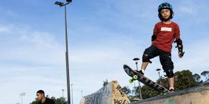 Eight-year-old Dinn works on his skateboarding skills at Sydney Park skate park.