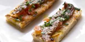Anchovy with tomato and garlic on grilled bread.