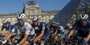 Yellow jersey Tadej Pogacar leads the peloton past the Louvre on Sunday.