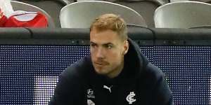 Harry McKay looks on from the bench after leaving the field.