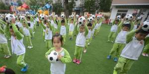 Kindergarten children do choreographed football exercises to teach them football culture at Yangzhou University Kindergarten,Jiangsu,China,in 2016.