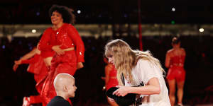 Taylor Swift givers her 22 hat to Scarlett Oliver at Accor Stadium on Friday night. The nine-year-old has been undergoing chemotherapy for a brain tumour. 