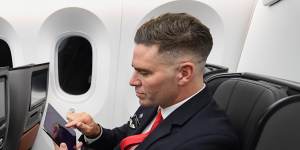 A cabin crew member takes a reaction test on an iPad onboard Qantas'long-haul test flight. 
