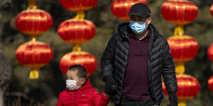 A man and child walk past lanterns at a public park in Beijing. While Beijing ended its controversial one-child policy in 2017,it had not yet published new family size limits.