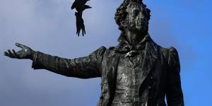 A crow tries to drive a seagull off the sculpture of famous Russian poet Aleksander Pushkin in St Petersburg,Russia.
