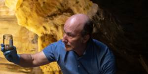 Water scientist Ian Wright takes a sample of PFAS-contaminated water in a sandstone canyon at Greaves Creek,below Medlow Dam.