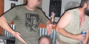 A senior SAS officer,left,and a non-commissioned officer,kneeling,pretend to engage in a sex act using an object designed to look like a penis at a party in the makeshift Fat Ladies Arms bar.