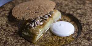 Wood-charred leek with cashew cream,brown butter and a crisp disc of chicken skin.