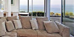 Window seat ... the Cliff's Edge living room has a comfy couch and a pillow-strewn day bed in a cosy corner.