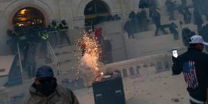 A flashbang grenade explodes as law enforcement officers push back demonstrators at the US Capitol building.