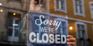 Woman holding We Are Closed sign.