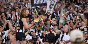 Beau McCreery holds the premiership cup while Bobby Hill kisses it.