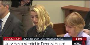 Amber Heard reacts,with her lawyer Elaine Bredehoft at right,as the verdict is read in the courtroom.