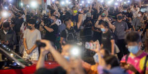 Supporters illuminate mobile phone torches outside the headquarters of the Apple Daily. 