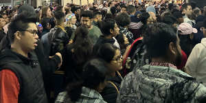 Commuters wait to get onto train platforms at Southern Cross Station in the early hours of 2024.