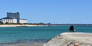 A fisher contemplates the water – or perhaps the CBH grain terminal and jetty.
