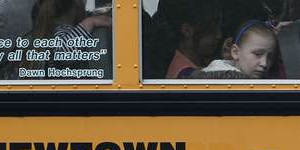 Children sit on a bus adorned with a quote from slain Sandy Hook school principal Dawn Hochsprung.