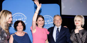 Premier Gladys Berejiklian,flanked by her family,arrives at the Sofitel Wentworth in Sydney on election night 2019.