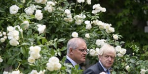 Prime ministers Scott Morrison and Boris Johnson walk to their joint press conference in the Downing Street garden.