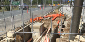 A pit near the intersection of the Federal Highway and Flemington Road in Canberra,where electrical cables appear to be installed just a few millimetres below ground level.