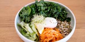 The breakfast bowl is served with poached egg,brown rice,raw kale and quinoa. 