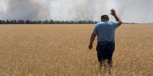 A farmer looks at his burning field caused by the fighting at the front line in the Dnipropetrovsk region,Ukraine.