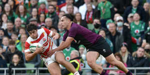 Kazuki Himeno of Japan is tackled by James Lowe of Ireland.