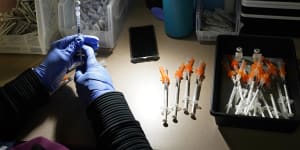 A nurse fills syringes with Pfizer vaccines at a COVID-19 vaccination clinic. 