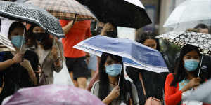 Protected but not over-protected:masked people in the rain in Singapore.