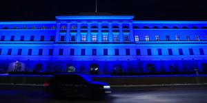 A car passes the Ministry of Foreign Affairs building illuminated in blue,in Helsinki. 