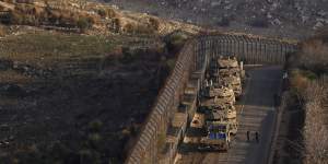 Israeli soldiers walk near armoured vehicles parked along the so-called Alpha Line that separates the Israeli-annexed Golan Heights from Syria.