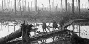 Soldiers walk on a duckboard across the shattered landscape during the Battle of Passchendaele in 1917. 