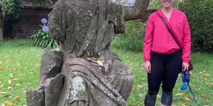 Look no hands:Emma Monger and dog Henry-James with Britannia’s torso behind a garden wall at a private garden in Hornsby Shire.