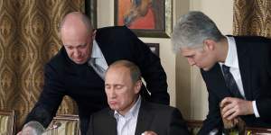 Businessman Yevgeny Prigozhin,left,serves Russian Prime Minister Vladimir Putin,centre,at his restaurant outside Moscow in 2011.