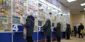 Customers stand at the windows buying medicines in a pharmacy in St Petersburg,Russia,last week.