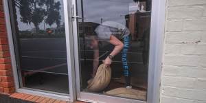 Jenny Bibby lays sandbags at her business in St Arnaud.