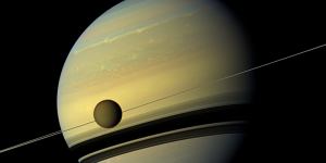 A giant of a moon appears before a giant of a planet undergoing seasonal changes in this natural colour view of Titan and Saturn from NASA's Cassini spacecraft. 