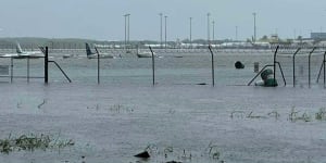 Planes partially submerged on the Cairns Airport tarmac in flooding caused by Cyclone Jasper.